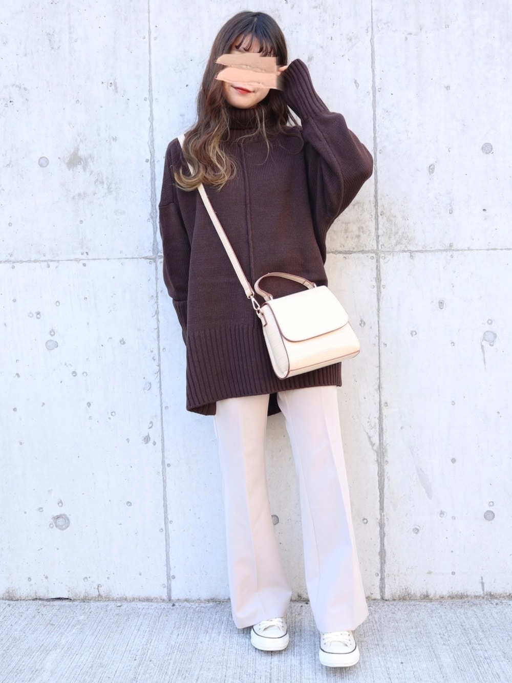 ブラウン系のニット/セーター、ベージュ系のパンツ、ベージュ系のハンドバッグを着用したレディースの秋コーディネートの1枚目の写真