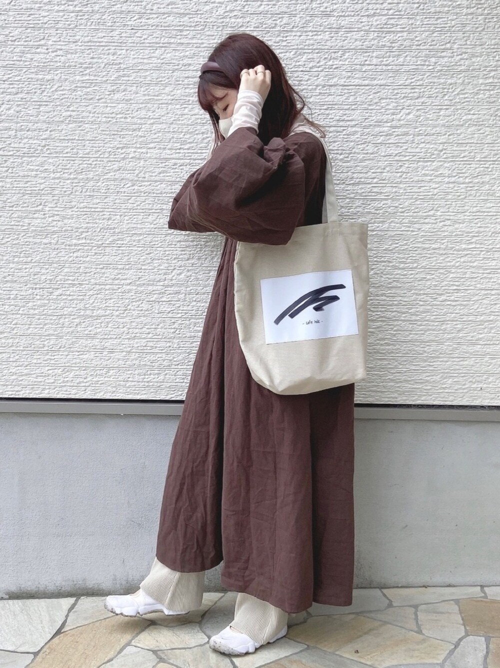 ブラウン系のワンピース、ホワイト系のTシャツ/カットソー、ベージュ系のその他パンツを着用したレディースの春コーディネートの1枚目の写真