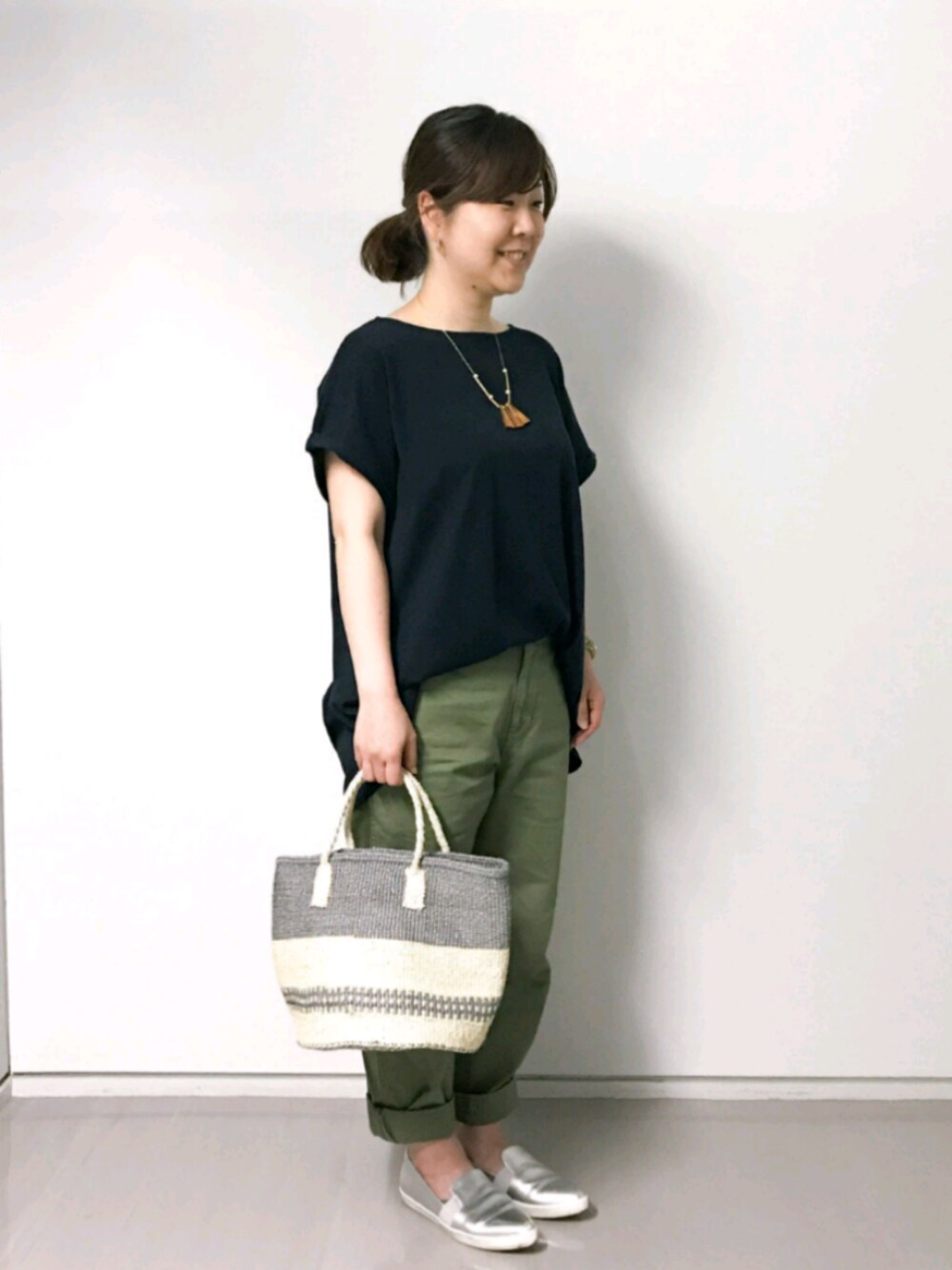 グレー系のショルダーバッグ、ブルー系のTシャツ/カットソー、グリーン系のチノパンツを着用したレディースの夏コーディネートの1枚目の写真