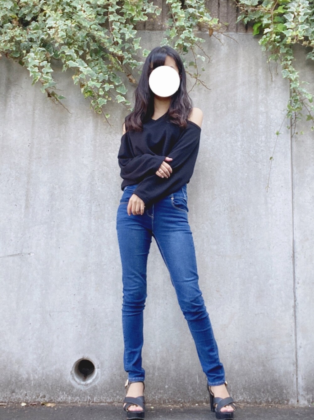 ブラック系のトップス、ブルー系のパンツ、ブラック系のシューズを着用したレディースの秋コーディネートの1枚目の写真