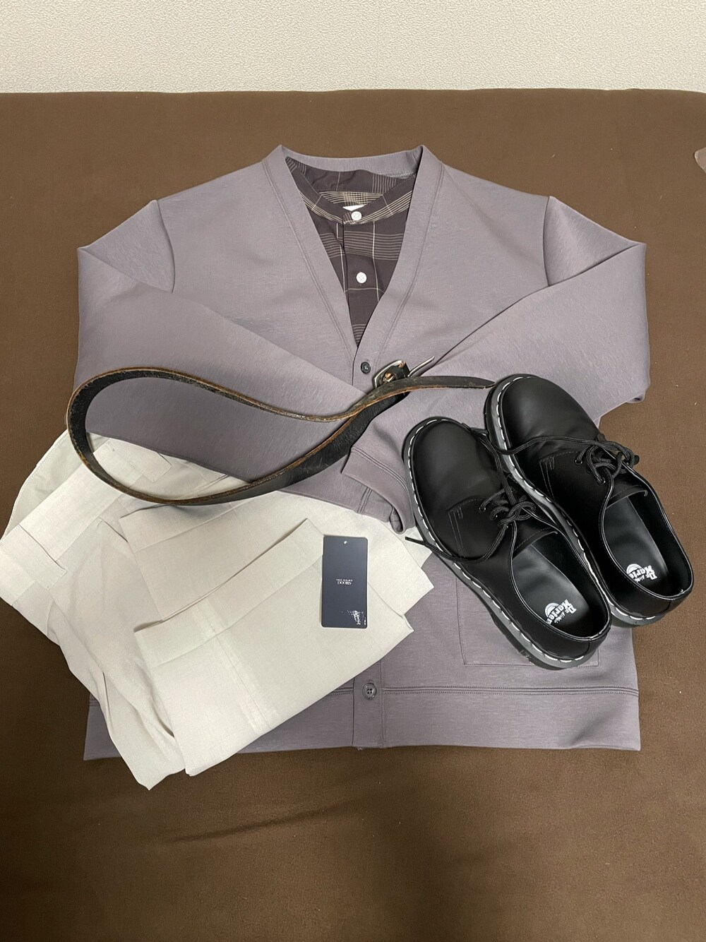 グレー系のカーディガン/ボレロ、ブラウン系のシャツ/ブラウス、ホワイト系のスラックスを着用したメンズの春コーディネートの1枚目の写真