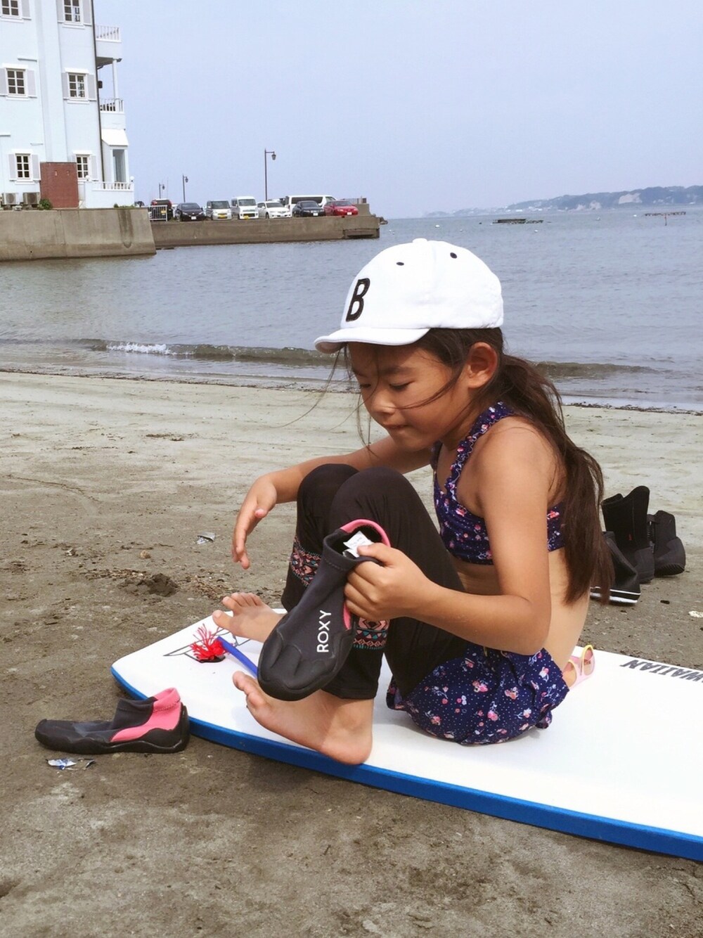 「夏コーデ、海コーデ、水着、ビキニ、レギンス、マリンシューズ、ボードショーツ、サーフパンツ、キャップ、花柄」｜「ROXYのMY SWEET FLOWER SET（水着、ブルー系）」を使った、マチュさん（キッズ・120cm）の夏コーディネートの1枚目の写真