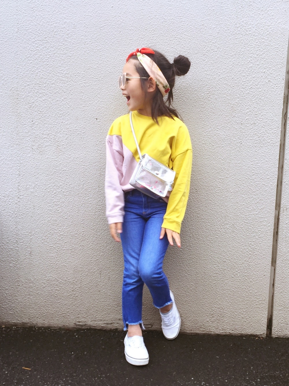 イエロー系のスウェット、ブルー系のデニムパンツ、シルバー系のショルダーバッグを着用したキッズの春コーディネートの1枚目の写真