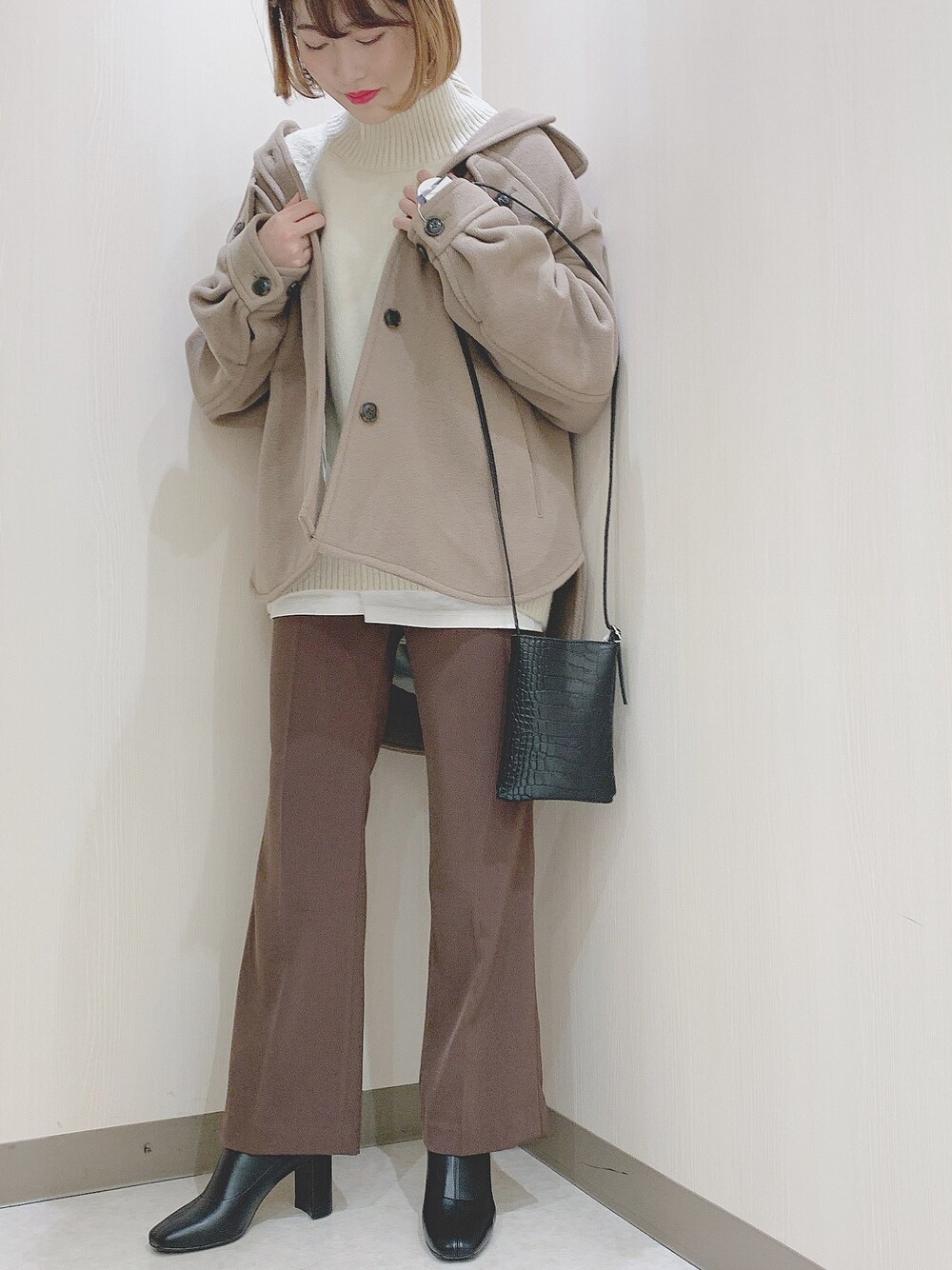 ベージュ系のその他アウター、ホワイト系のニット/セーター、ホワイト系のTシャツ/カットソーを着用したレディースの冬コーディネートの1枚目の写真
