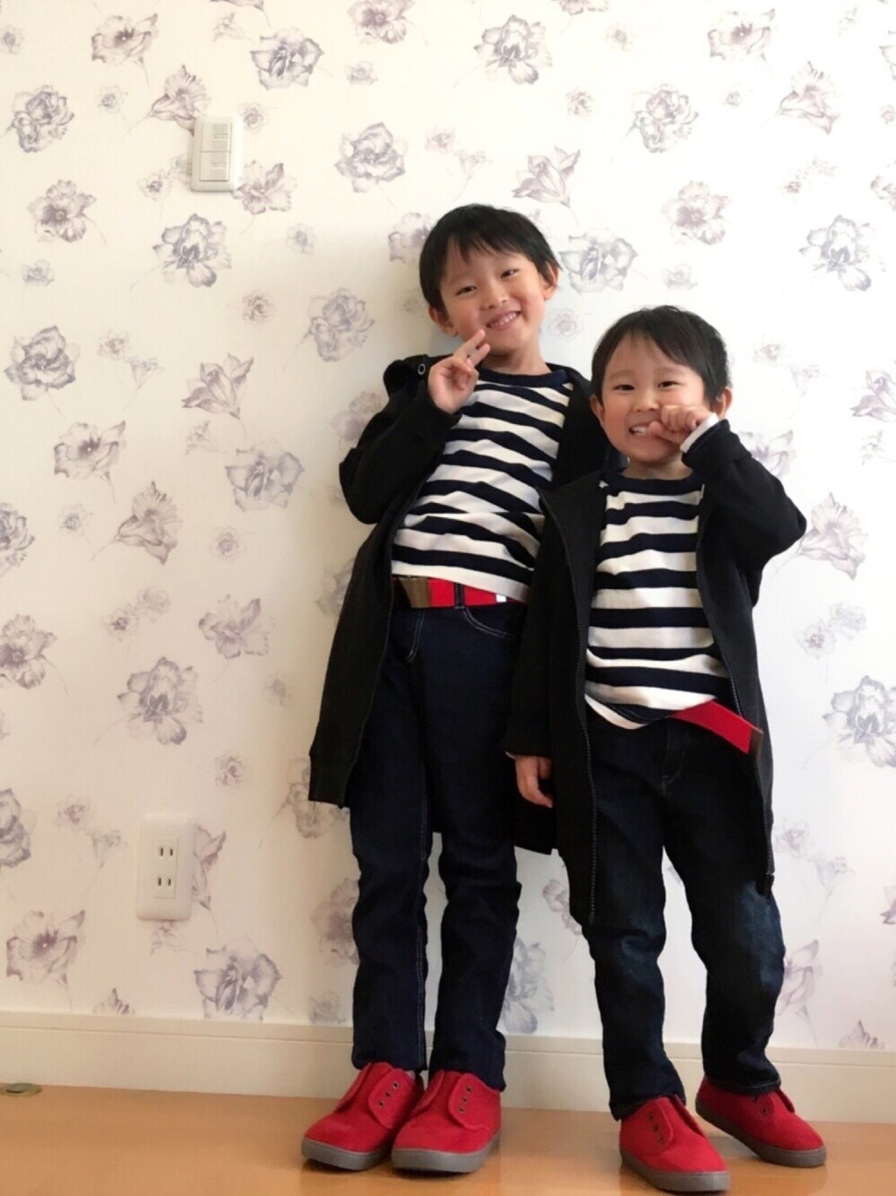 ブルー系のデニムパンツ、レッド系のスニーカー、ブラック系のパーカーを着用したキッズの冬コーディネートの1枚目の写真