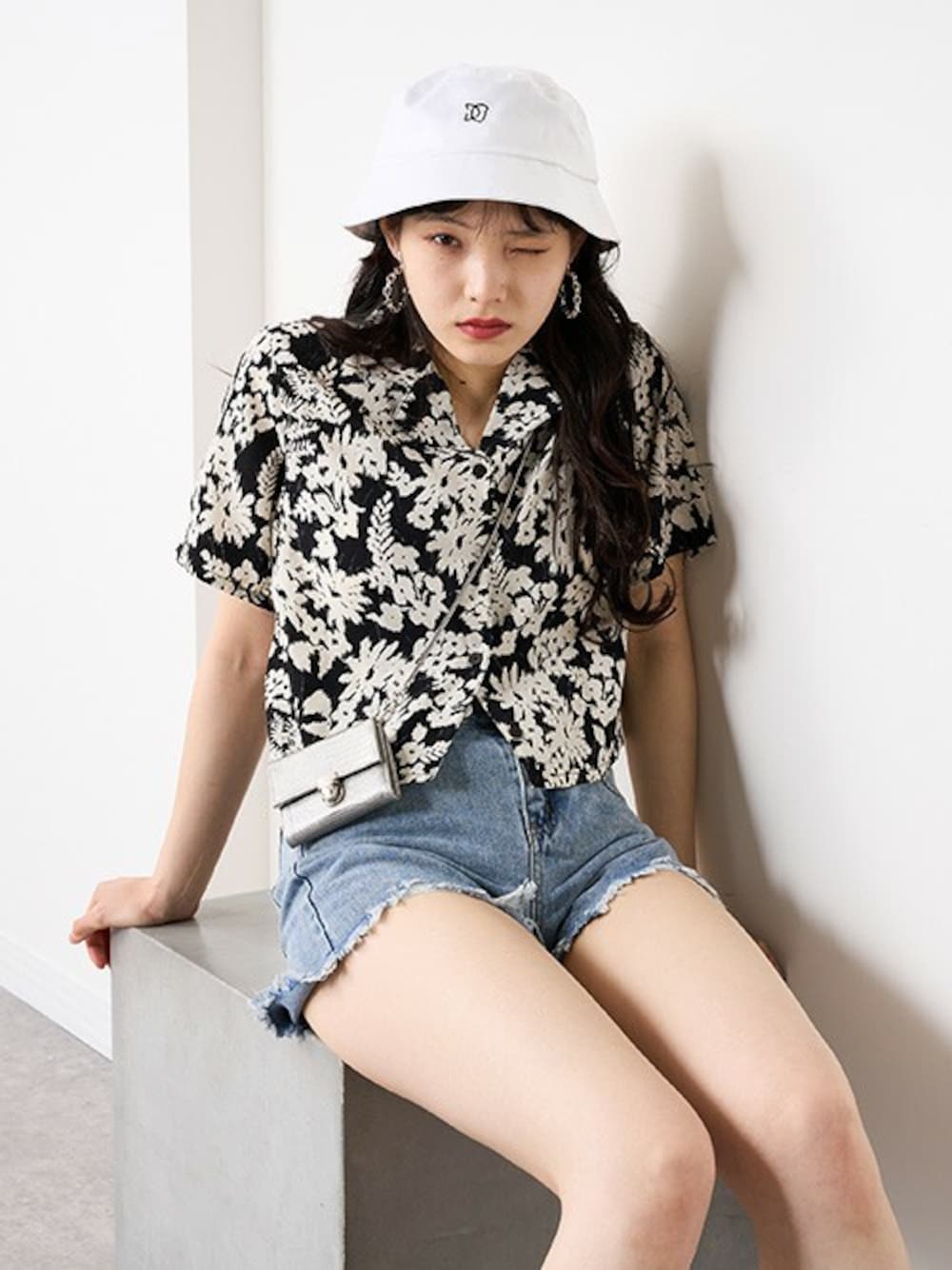 「柄シャツ、ショートパンツ、花柄シャツ、デニムショートパンツ、ダメージデニム、バケットハット、ショート丈トップス、オープンカラーシャツ、RASVOA、ラスボア」｜「RASVOAのオープンカラーショートシャツ（シャツ/ブラウス、ブラック系）」を使った、RASVOA STAFFさん（レディース・164cm）の春コーディネートの1枚目の写真