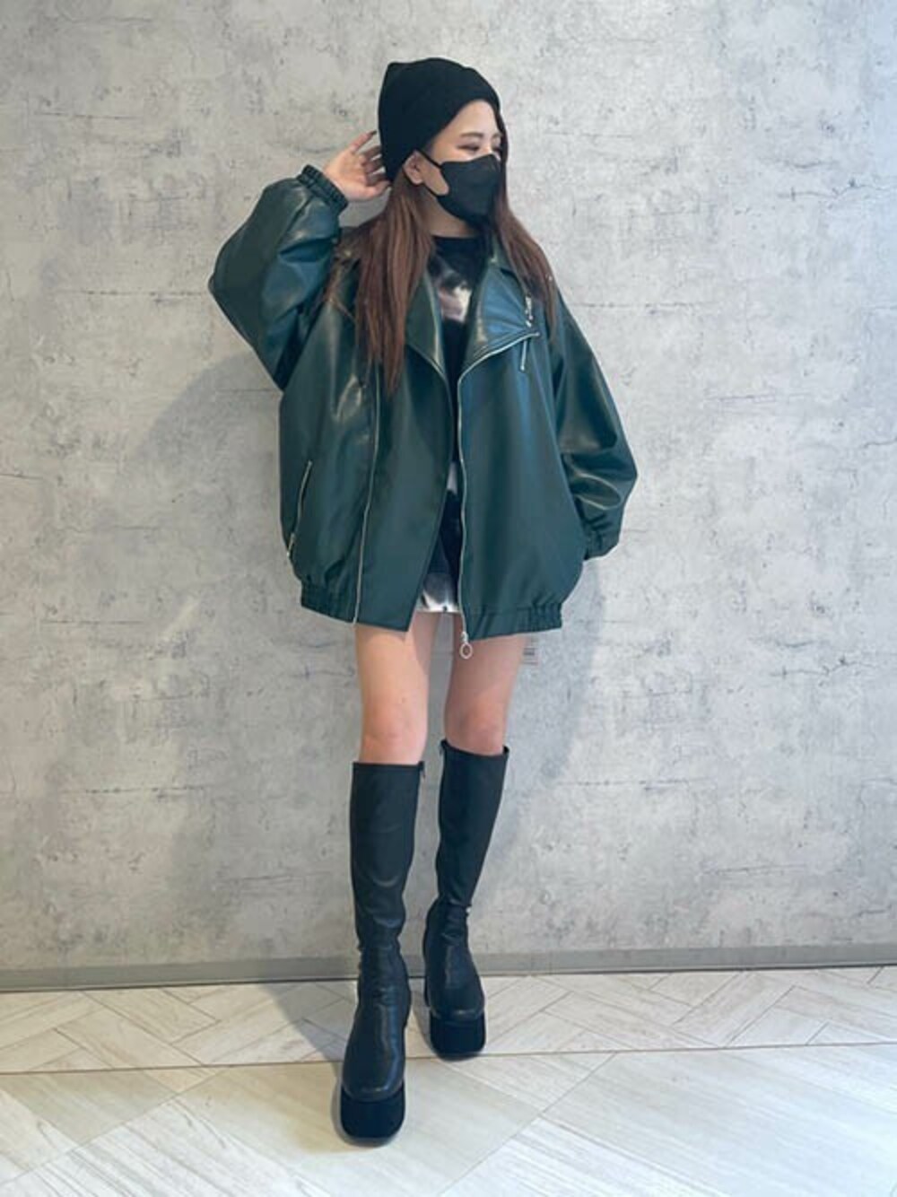 グリーン系のライダースジャケット、ブラック系のスウェット、ブラック系のブーツを着用したレディースの冬コーディネートの1枚目の写真