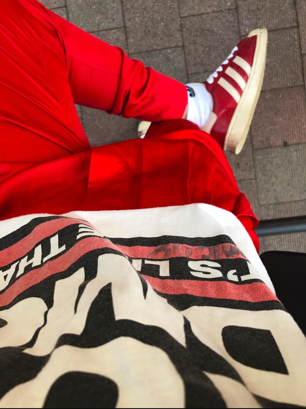 レッド系のパンツ、レッド系のスニーカー、ホワイト系のTシャツ/カットソーを着用したレディースの春コーディネートの1枚目の写真