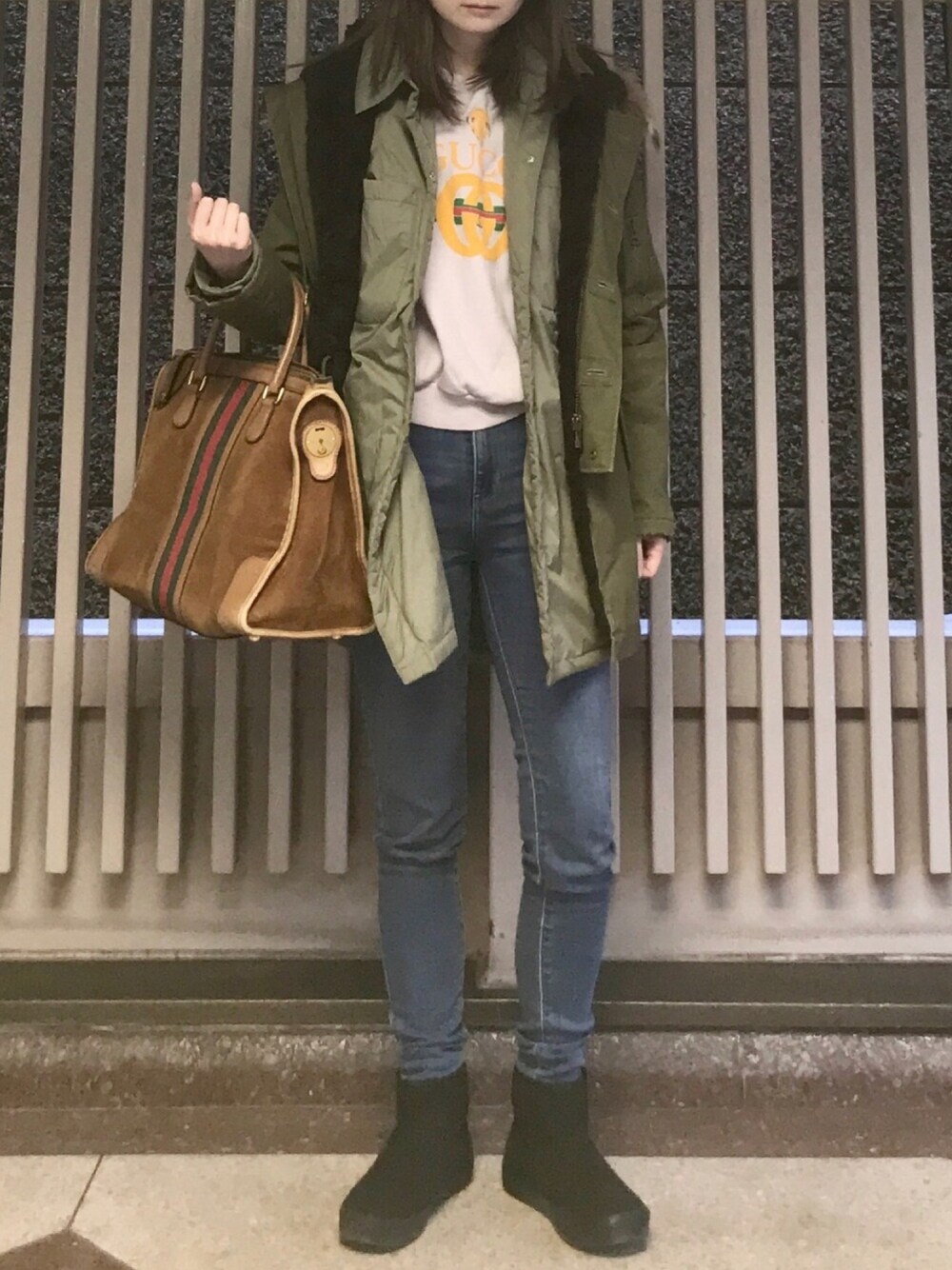 ブルー系のデニムパンツ、パープル系のスウェット、グリーン系のダウンジャケット/コートを着用したレディースの冬コーディネートの1枚目の写真