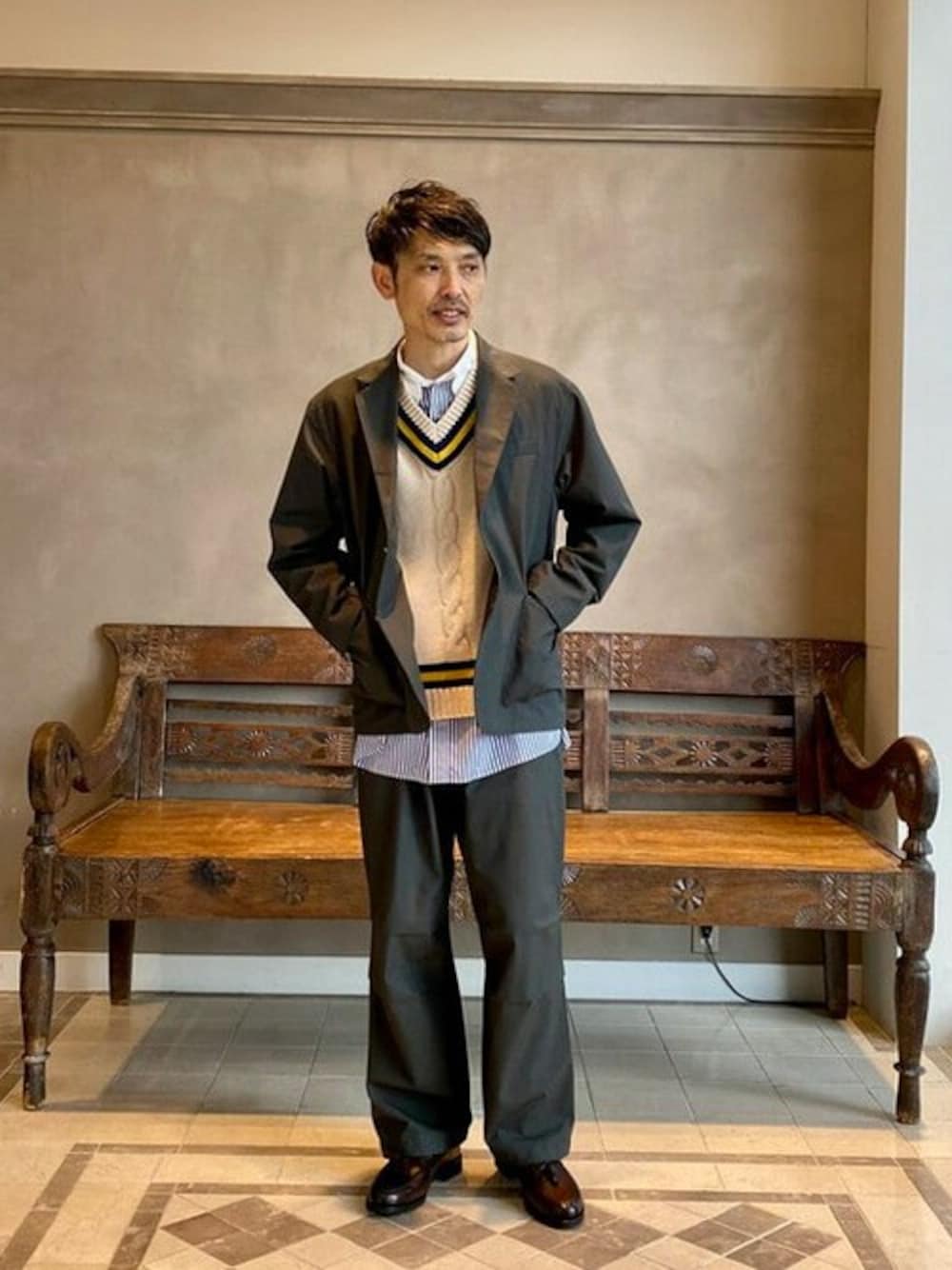 グレー系のテーラードジャケット、ベージュ系のベスト、ブルー系のシャツ/ブラウスを着用したメンズの冬コーディネートの1枚目の写真