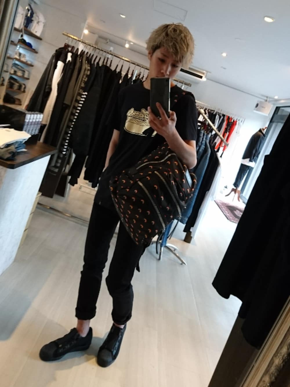 ブラック系のTシャツ/カットソー、ブラック系のバックパック/リュック、ブラック系のデニムパンツを着用したメンズの春コーディネートの1枚目の写真