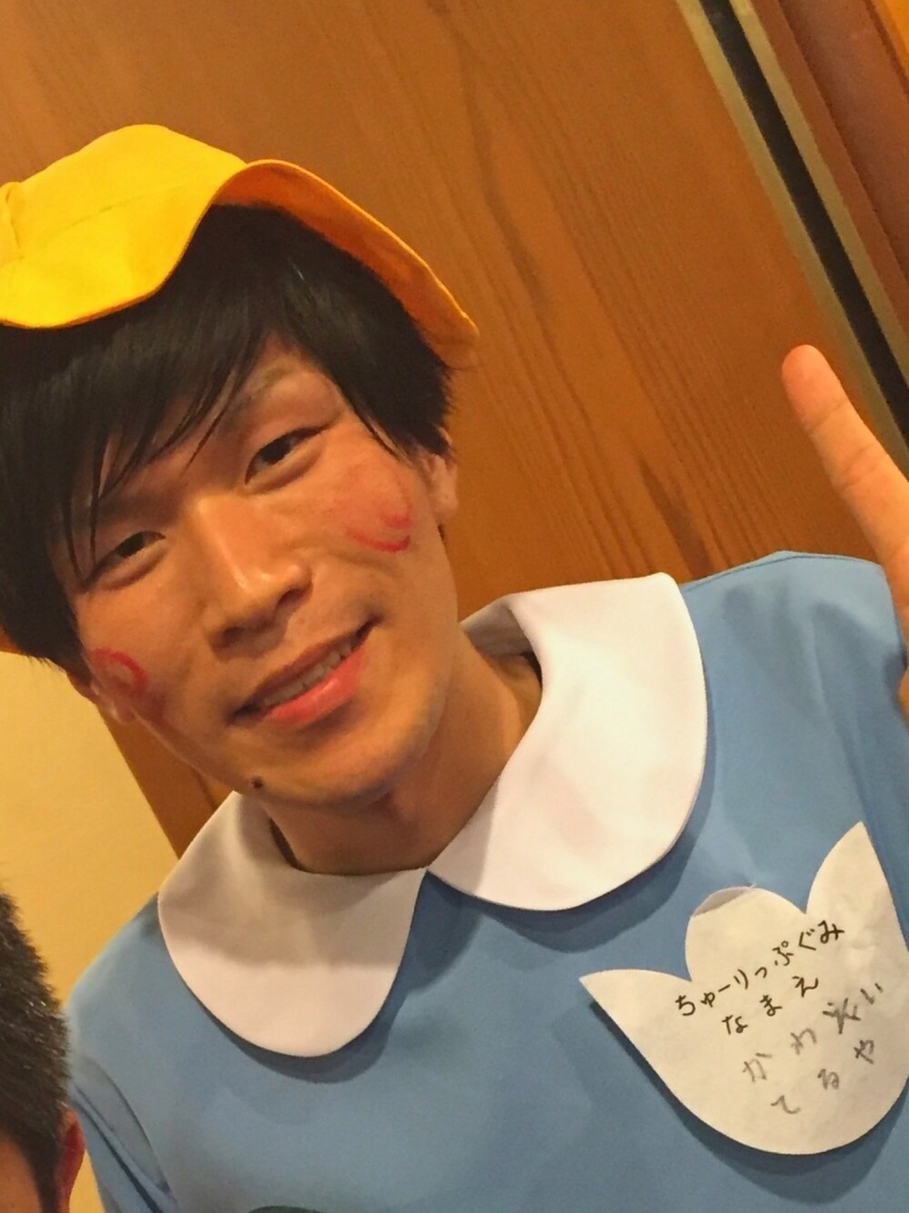 ブルー系のポンチョ、イエロー系のハット、ホワイト系のブローチ/コサージュを着用したメンズの春コーディネートの1枚目の写真