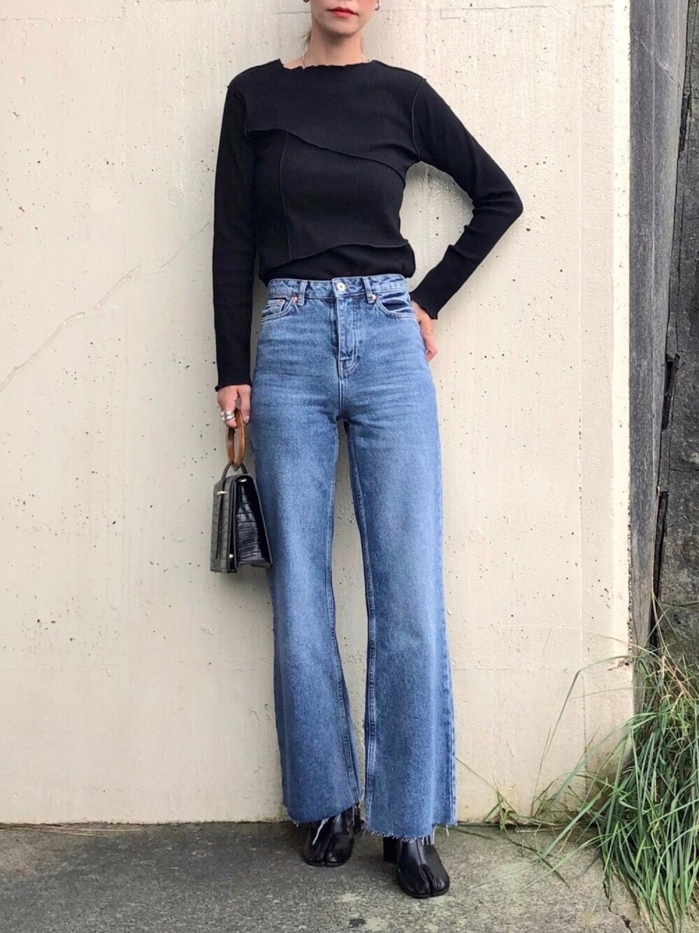 ブラック系のTシャツ/カットソー、ブルー系のデニムパンツ、ブラック系のハンドバッグを着用したレディースの秋コーディネートの1枚目の写真