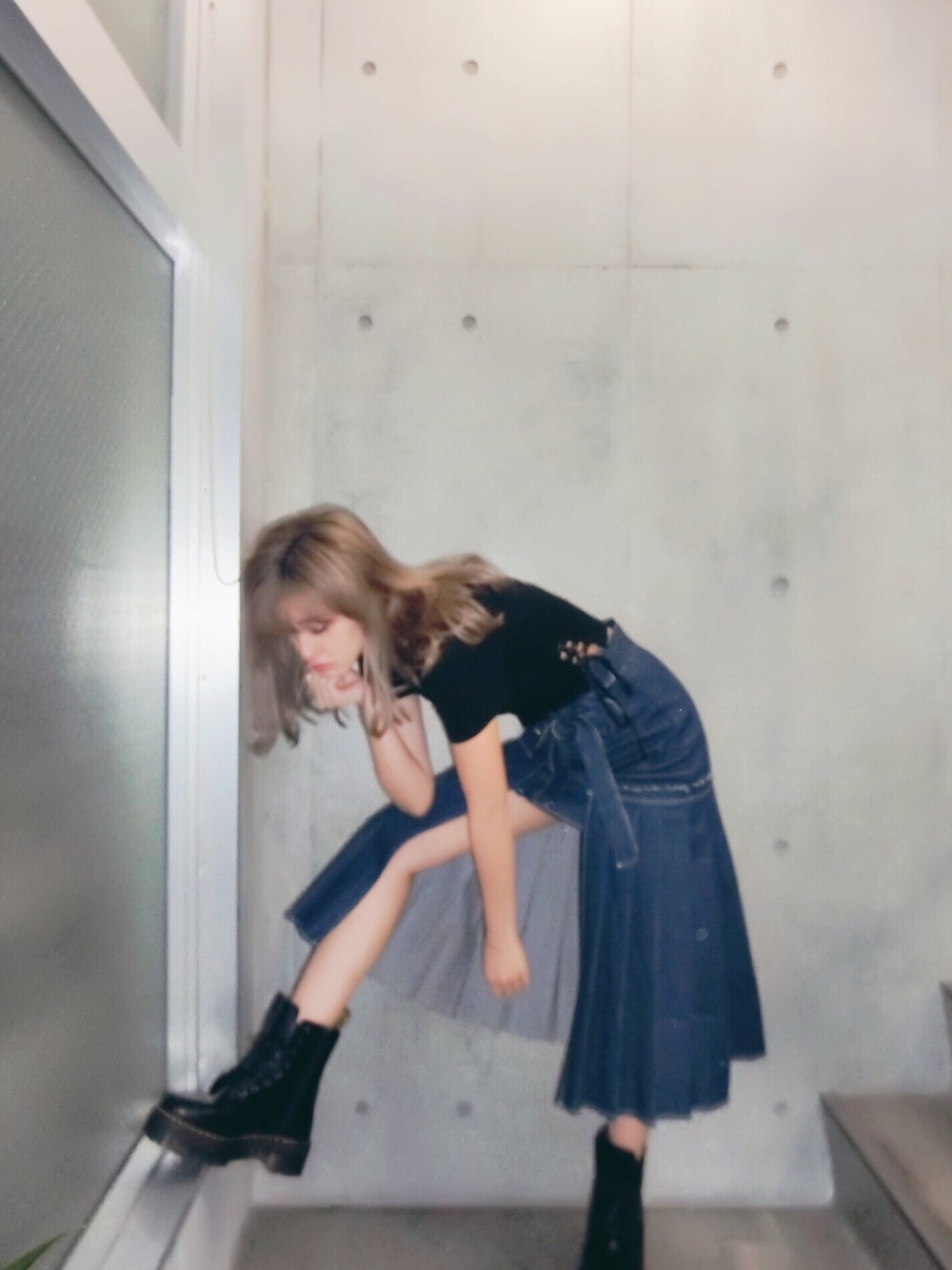 ブラック系のTシャツ/カットソー、ブルー系のデニムスカート、ブルー系のデニムスカートを着用したレディースの春コーディネートの1枚目の写真