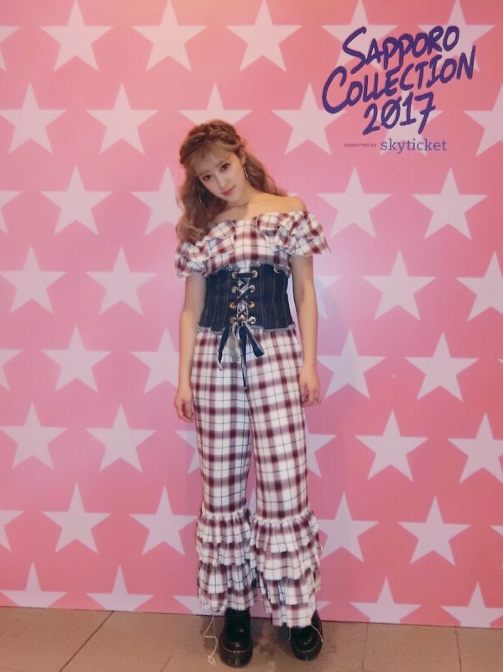 レッド系のオールインワン・サロペット、ブラック系のブーツ、ブルー系のベルトを着用したレディースの春コーディネートの1枚目の写真