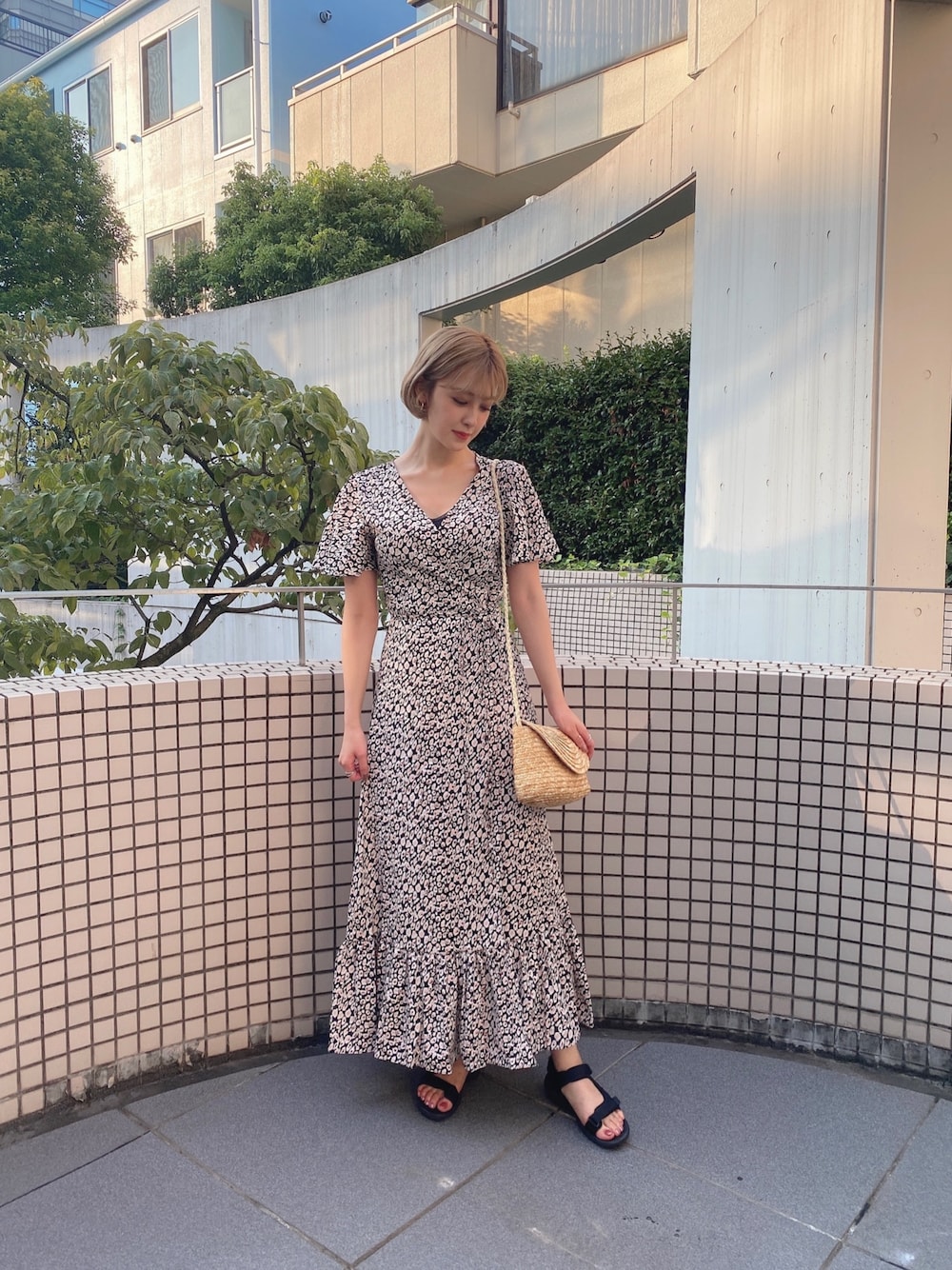 ブラック系のワンピース、ベージュ系のかごバッグを着用したレディースの夏コーディネートの1枚目の写真