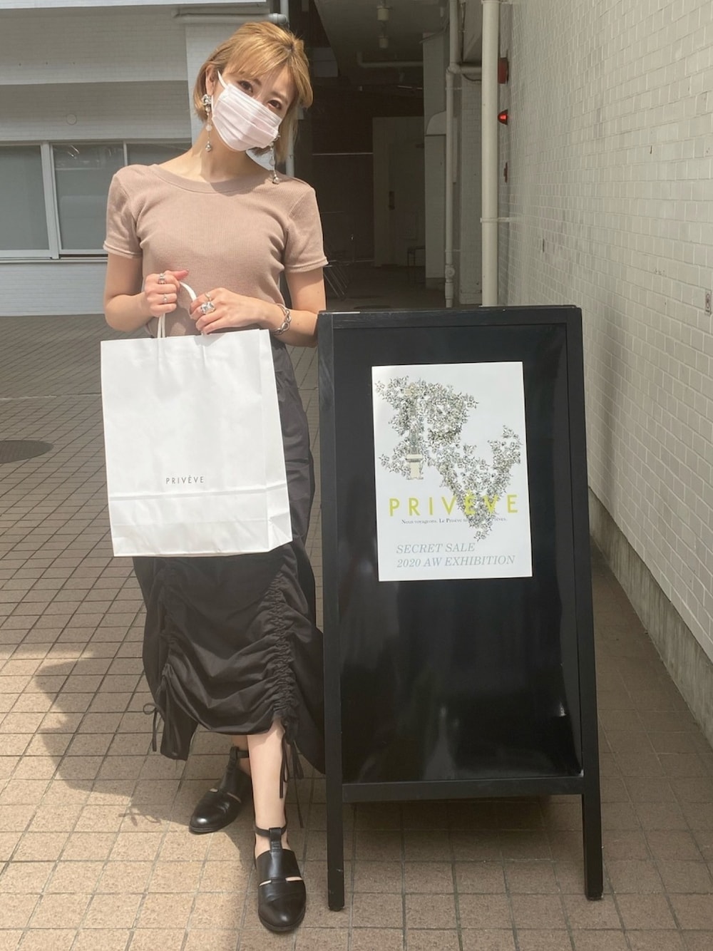 ブラック系のスカート、ベージュ系のTシャツ/カットソー、ホワイト系のその他を着用したレディースの夏コーディネートの1枚目の写真