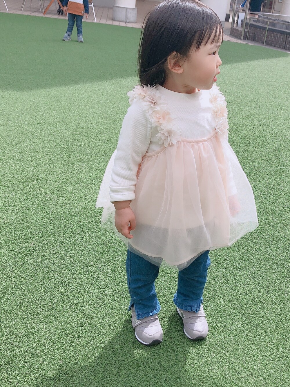 ピンク系のチュニック、ブルー系のその他パンツ、グレー系のスニーカーを着用したキッズの春コーディネートの1枚目の写真