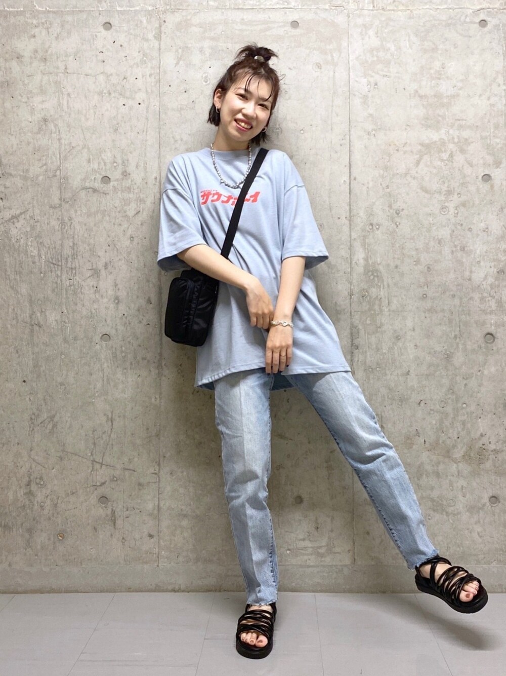 ブルー系のTシャツ/カットソー、ブラック系のショルダーバッグ、ブルー系のデニムパンツを着用したレディースの春コーディネートの1枚目の写真