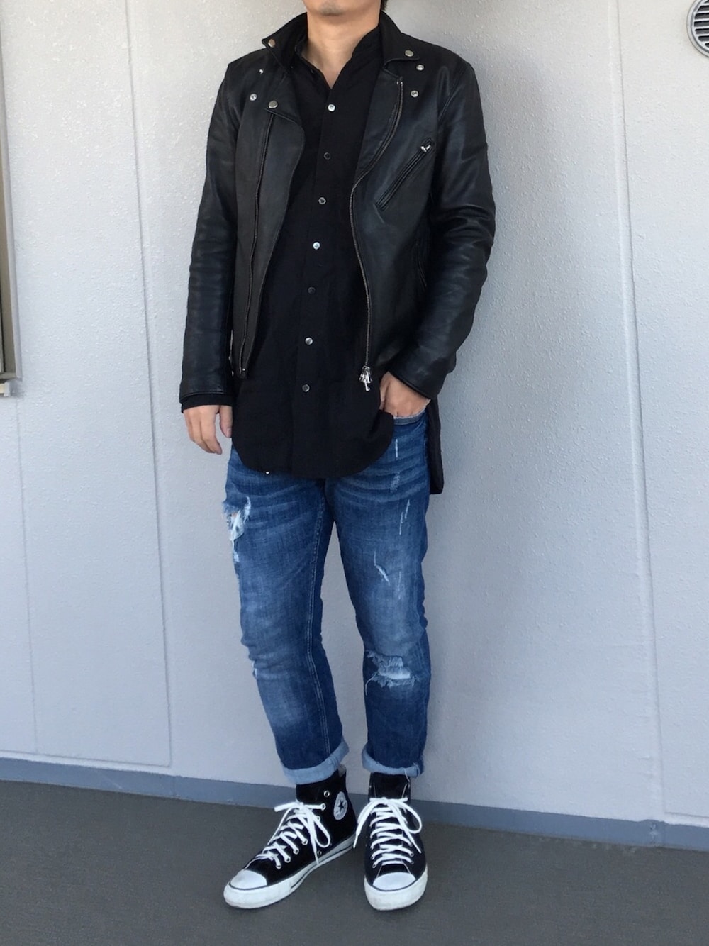 ブラック系のスニーカー、ブラック系のライダースジャケットを着用したメンズの春コーディネートの1枚目の写真
