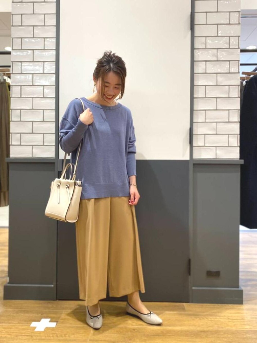 ブルー系のニット/セーター、イエロー系のその他パンツ、ホワイト系のショルダーバッグを着用したレディースの冬コーディネートの1枚目の写真