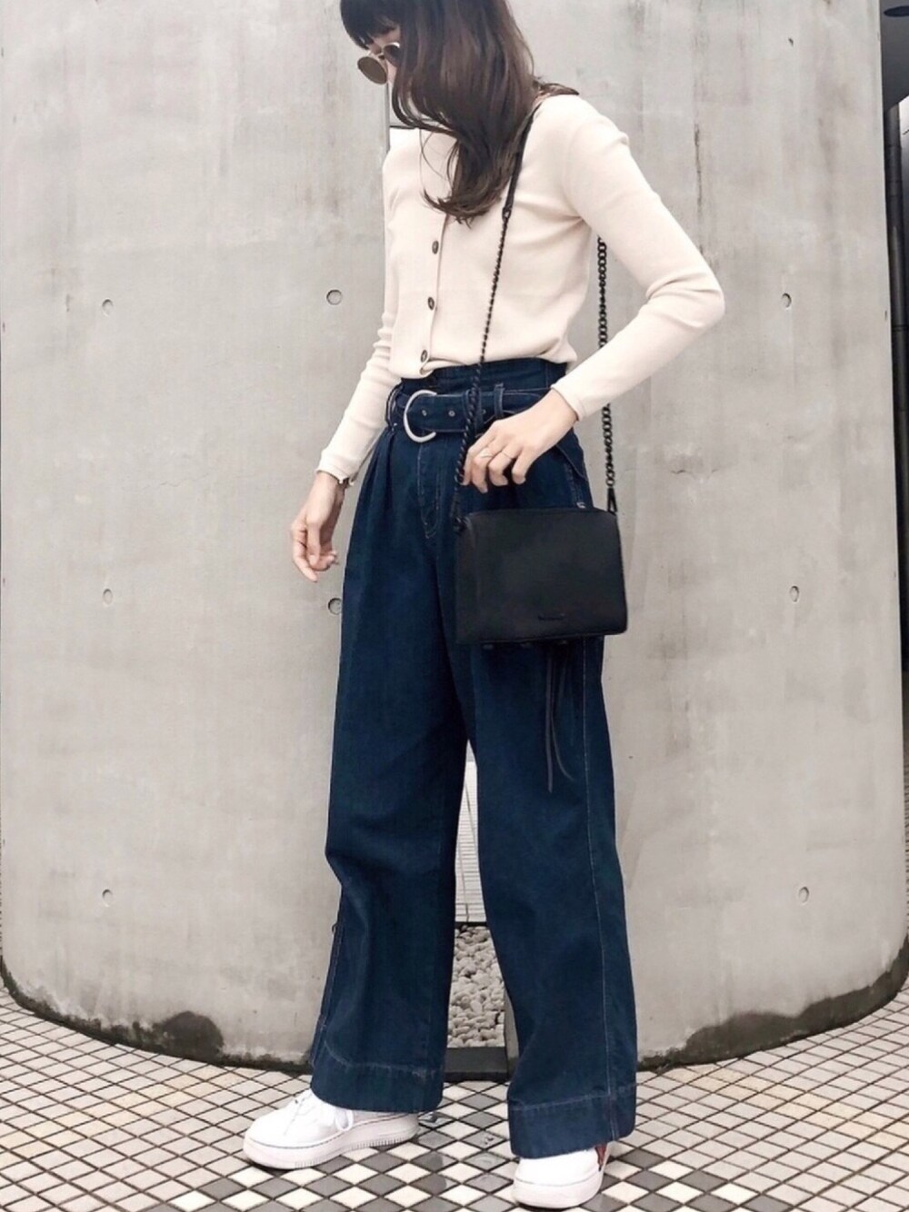 ブラック系のショルダーバッグ、ブルー系のデニムパンツ、ホワイト系のカーディガン/ボレロを着用したレディースの秋コーディネートの1枚目の写真