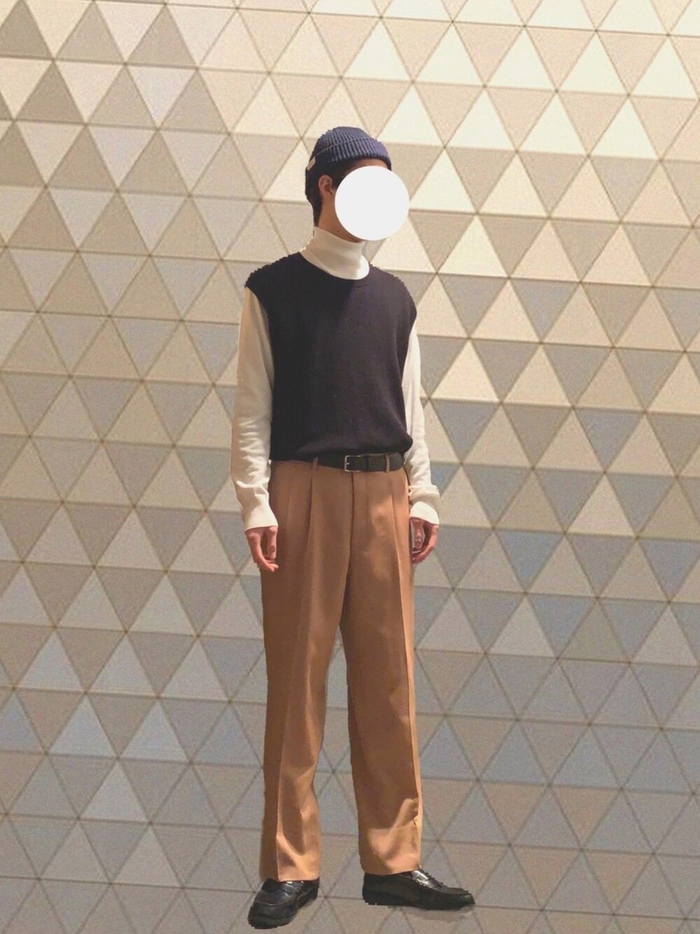 ホワイト系のニット/セーター、ブラック系のニット/セーター、オレンジ系のスラックスを着用したメンズの冬コーディネートの1枚目の写真