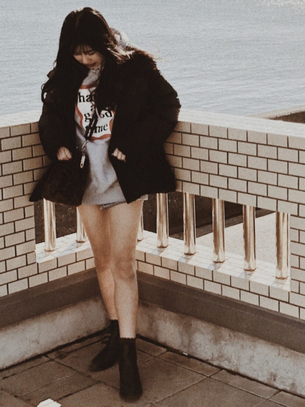 ブラック系のダウンジャケット/コート、グレー系のパーカー、ブラック系のブーツを着用したレディースの冬コーディネートの1枚目の写真