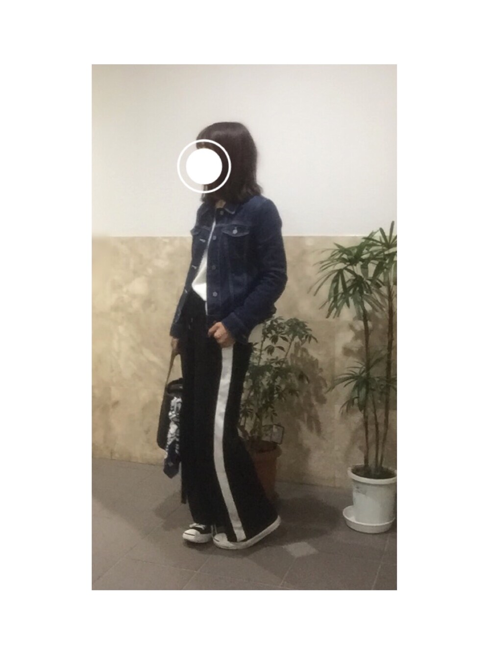 ブルー系のデニムジャケット、ブラック系のパンツ、ブラック系のショルダーバッグを着用したレディースの春コーディネートの1枚目の写真