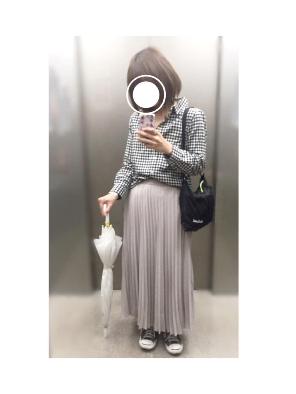 ブラック系のショルダーバッグ、グレー系のスカート、ブラック系のスニーカーを着用したレディースの春コーディネートの1枚目の写真