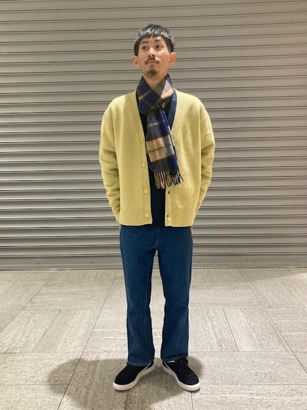 ブルー系のTシャツ/カットソー、ブラック系のスニーカー、ベージュ系のカーディガン/ボレロを着用したメンズの冬コーディネートの1枚目の写真