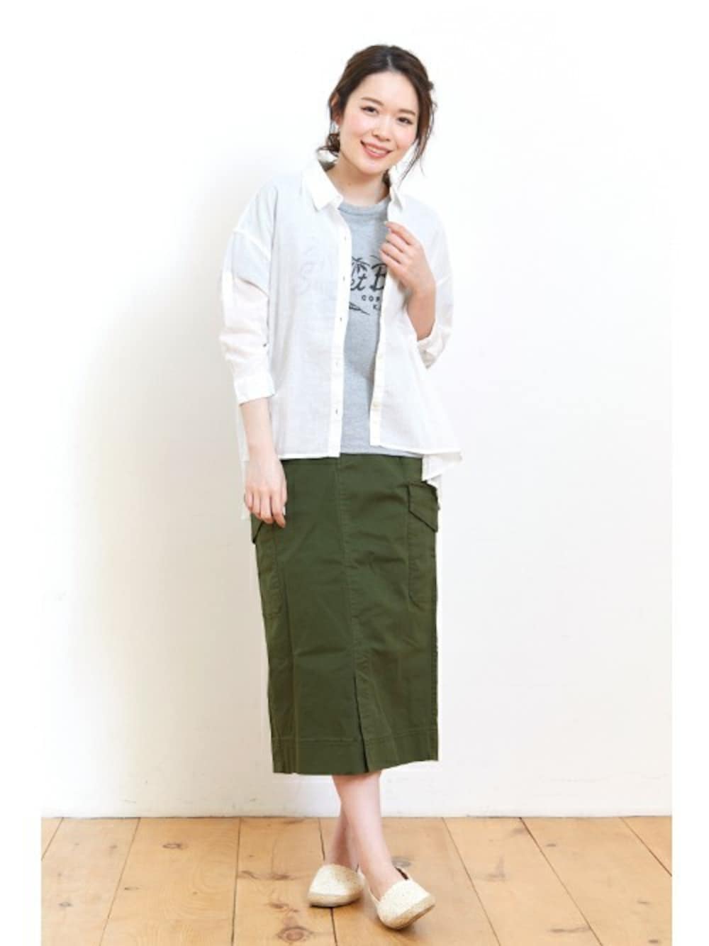 グリーン系のスカート、ホワイト系のシャツ/ブラウス、グレー系のTシャツ/カットソーを着用したレディースの夏コーディネートの1枚目の写真