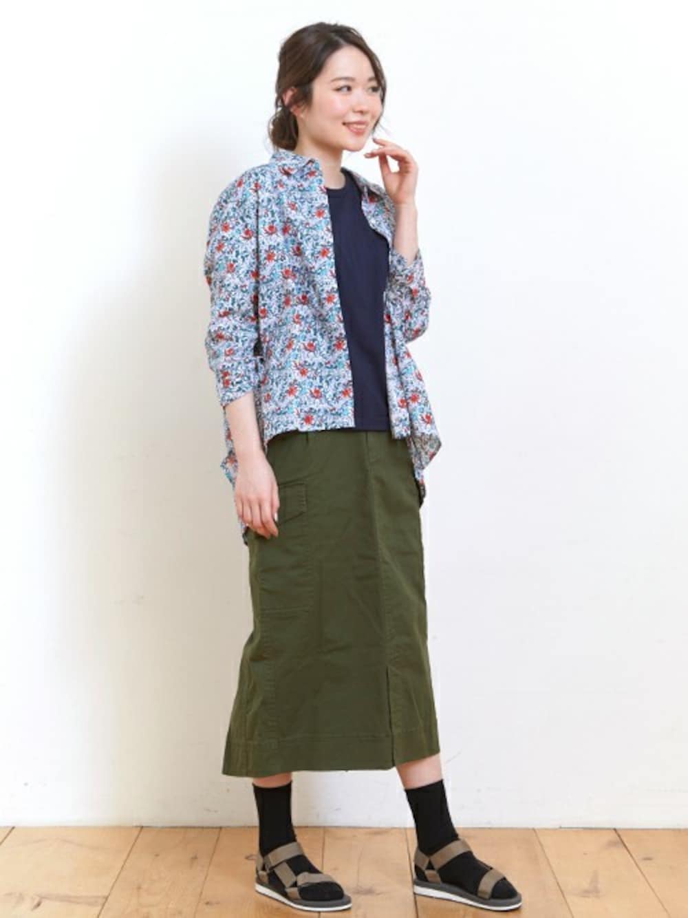ホワイト系のシャツ/ブラウス、グリーン系のスカート、ブルー系のTシャツ/カットソーを着用したレディースの夏コーディネートの1枚目の写真