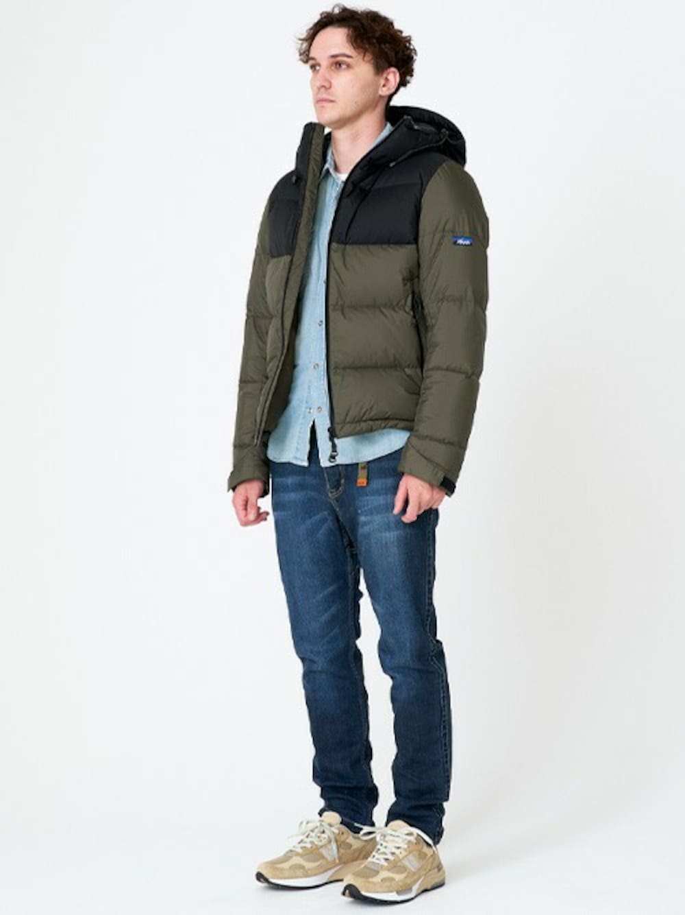 グリーン系のダウンジャケット/コート、ブルー系のシャツ/ブラウス、ブルー系のデニムパンツを着用したメンズの冬コーディネートの1枚目の写真