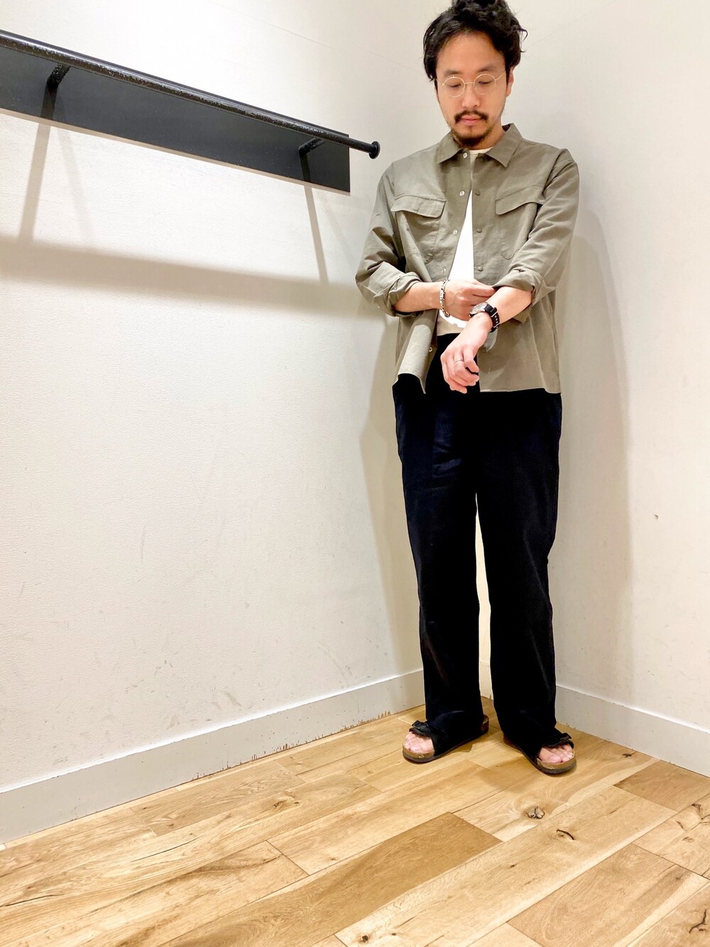 グリーン系のシャツ/ブラウス、ブルー系のチノパンツ、ブラック系のサンダルを着用したメンズの春コーディネートの1枚目の写真
