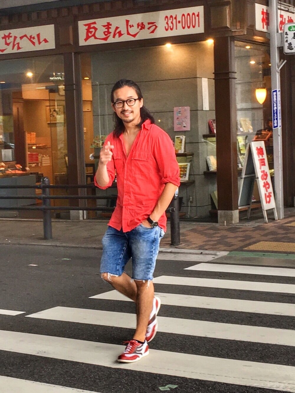 ホワイト系のスニーカー、レッド系のシャツ/ブラウス、ブルー系のパンツを着用したメンズの夏コーディネートの1枚目の写真