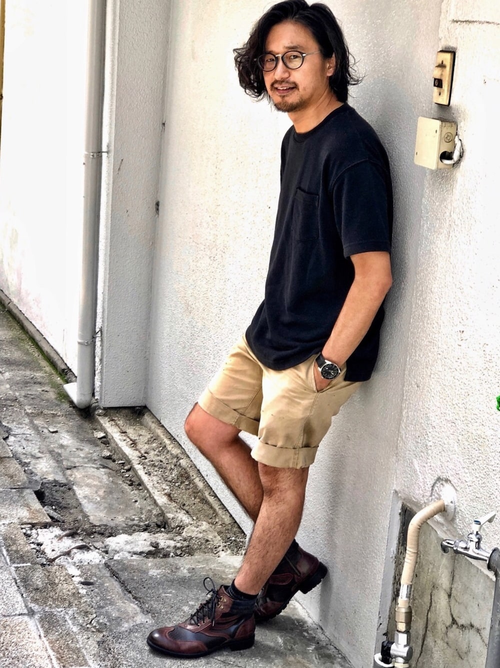 ブラウン系のブーツ、ベージュ系のチノパンツ、ブラック系のTシャツ/カットソーを着用したメンズの夏コーディネートの1枚目の写真