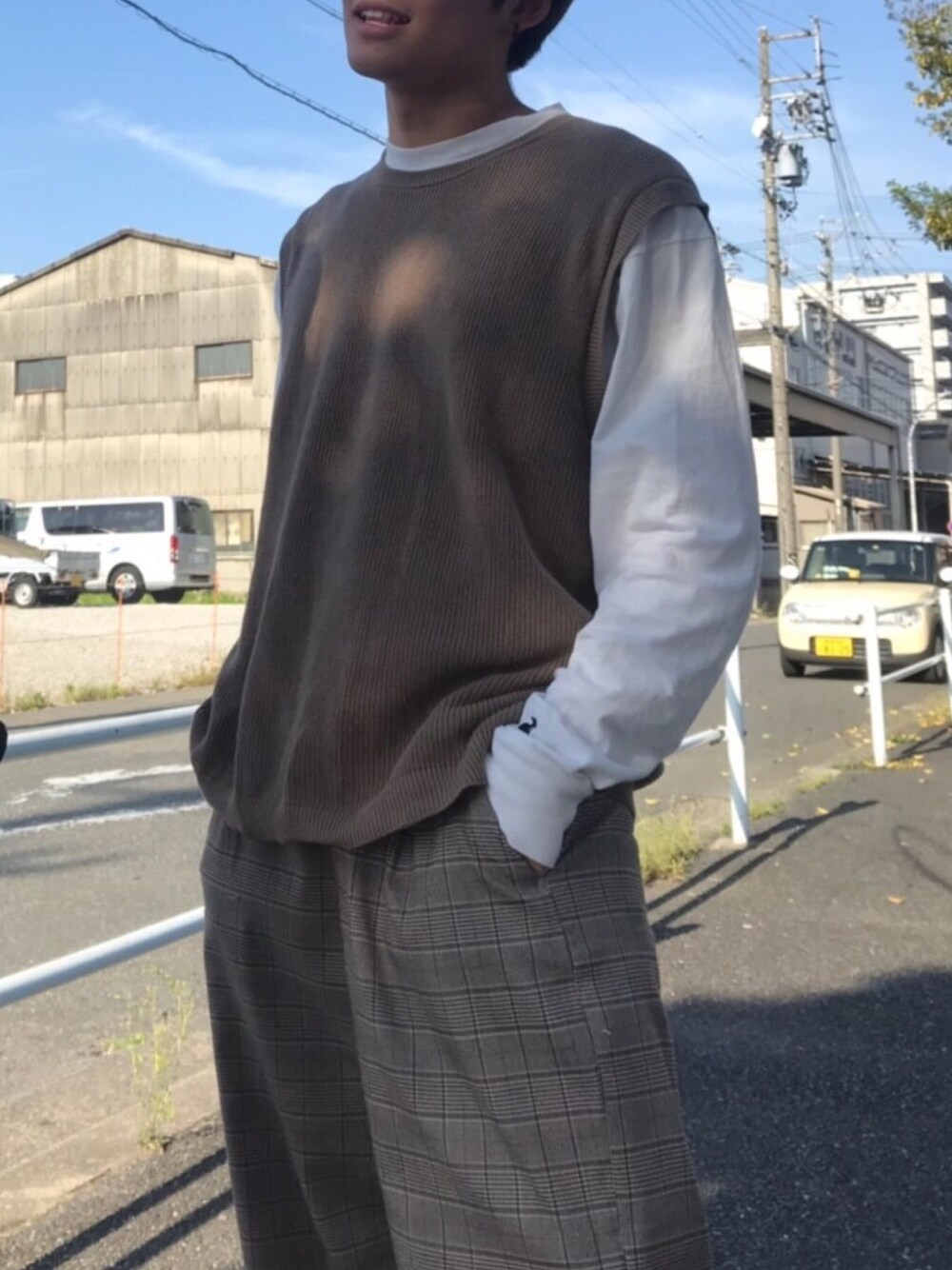 ブラウン系のニット/セーター、ホワイト系のTシャツ/カットソー、グレー系のスラックスを着用したメンズの秋コーディネートの1枚目の写真