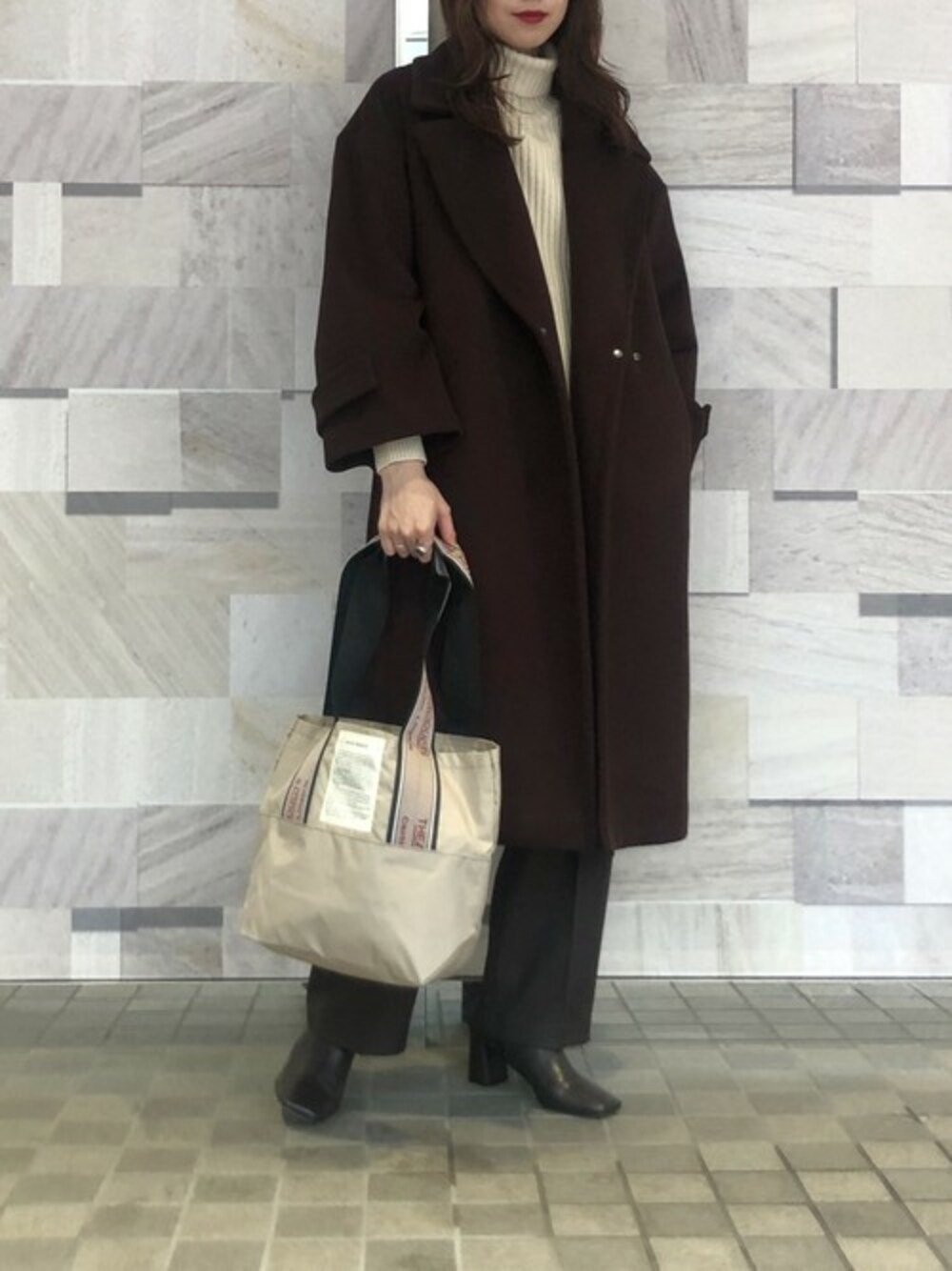 「チェスターコート、スラックス、タートルニット、レイヤードスタイル、タートルネック、大人カジュアル、タートルネックニット、通勤コーデ、ブラウンコーデ、秋冬コーデ」｜「THEATRE PRODUCTSの【THEATRE PRODUCTS(シアタープロダクツ)】ジャガードテープバッグ　BL180601（トートバッグ、ベージュ系）」を使った、近藤 真梨さん（レディース・165cm）の秋コーディネートの1枚目の写真