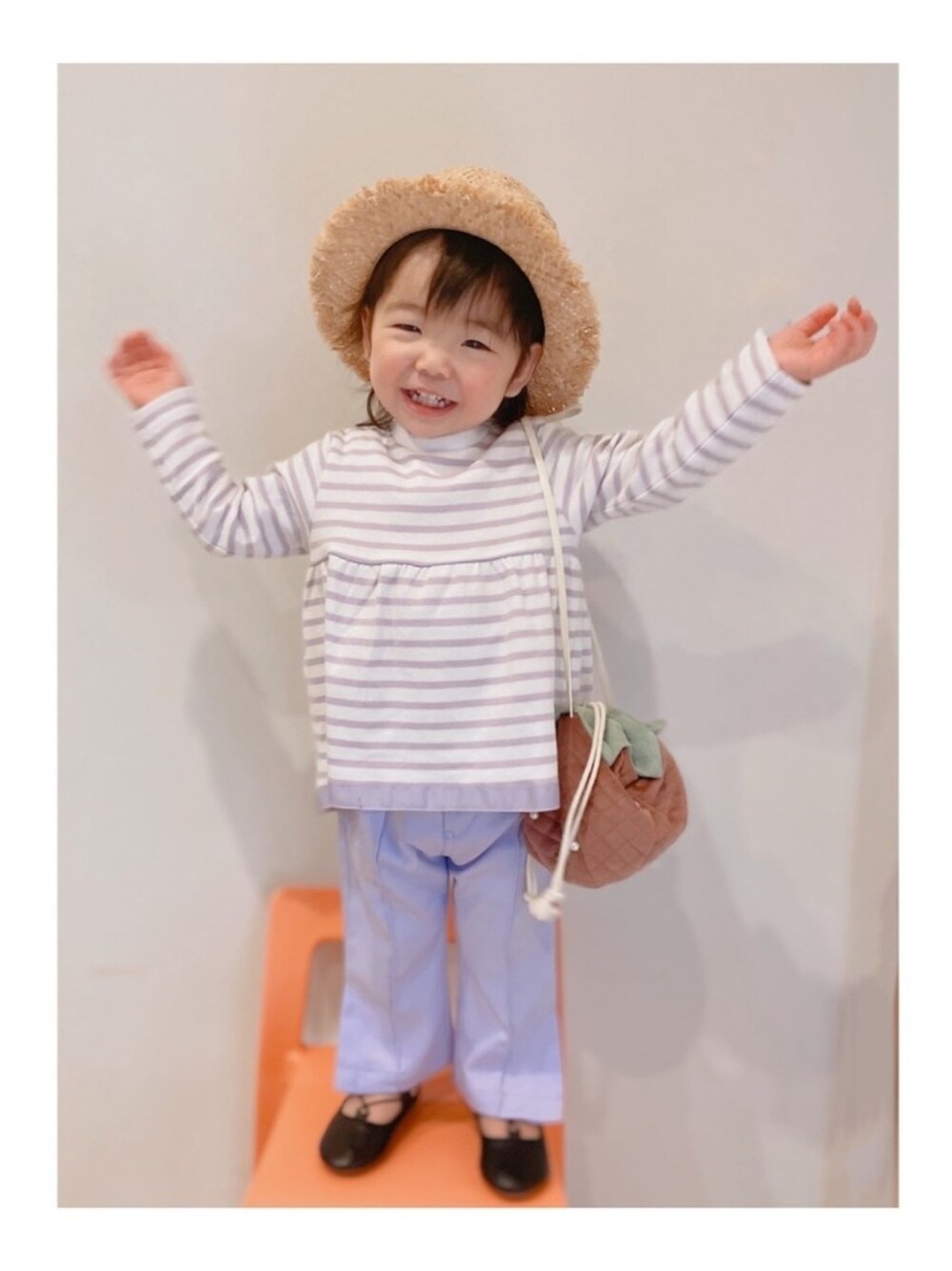 パープル系のTシャツ/カットソー、パープル系のスラックス、ピンク系のショルダーバッグを着用したキッズの春コーディネートの1枚目の写真
