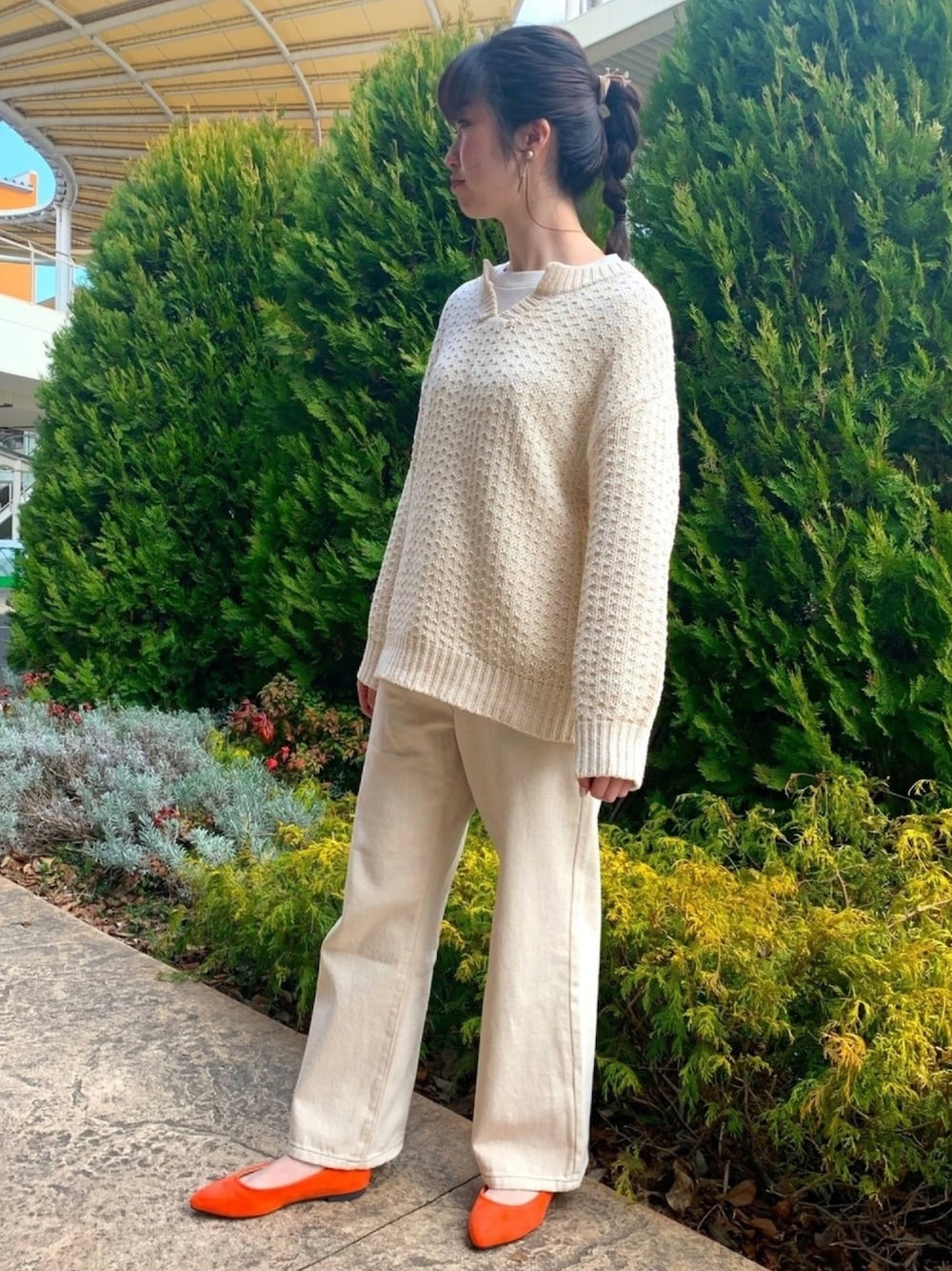 ホワイト系のニット/セーター、ホワイト系のTシャツ/カットソー、ホワイト系のデニムパンツを着用したレディースの冬コーディネートの1枚目の写真