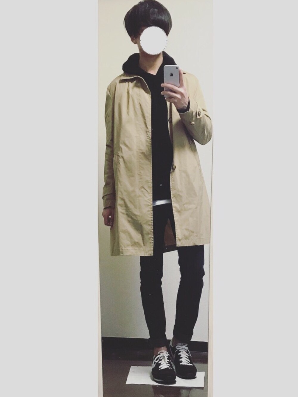 ブラック系のパーカー、ベージュ系のステンカラーコート、ブラック系のデニムパンツを着用したメンズの冬コーディネートの1枚目の写真