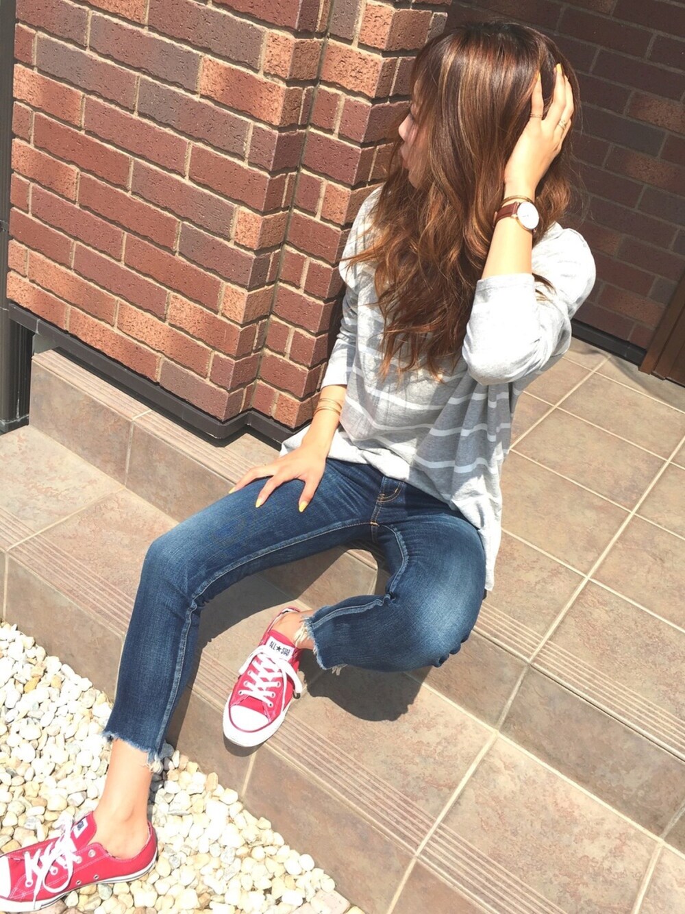 グレー系のTシャツ/カットソー、ブルー系のデニムパンツ、レッド系のスニーカーを着用したレディースの春コーディネートの1枚目の写真