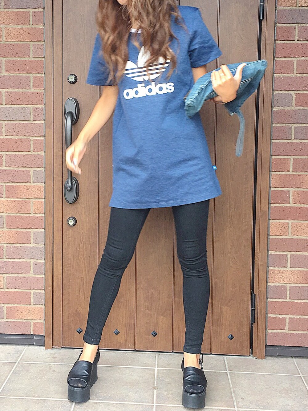 ブルー系のTシャツ/カットソー、ブルー系のクラッチバッグ、ブラック系のサンダルを着用したレディースの秋コーディネートの1枚目の写真