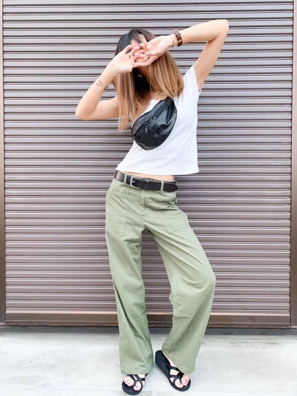 グリーン系のその他パンツ、ブラック系のサンダル、ブラック系のバッグを着用したレディースの夏コーディネートの1枚目の写真