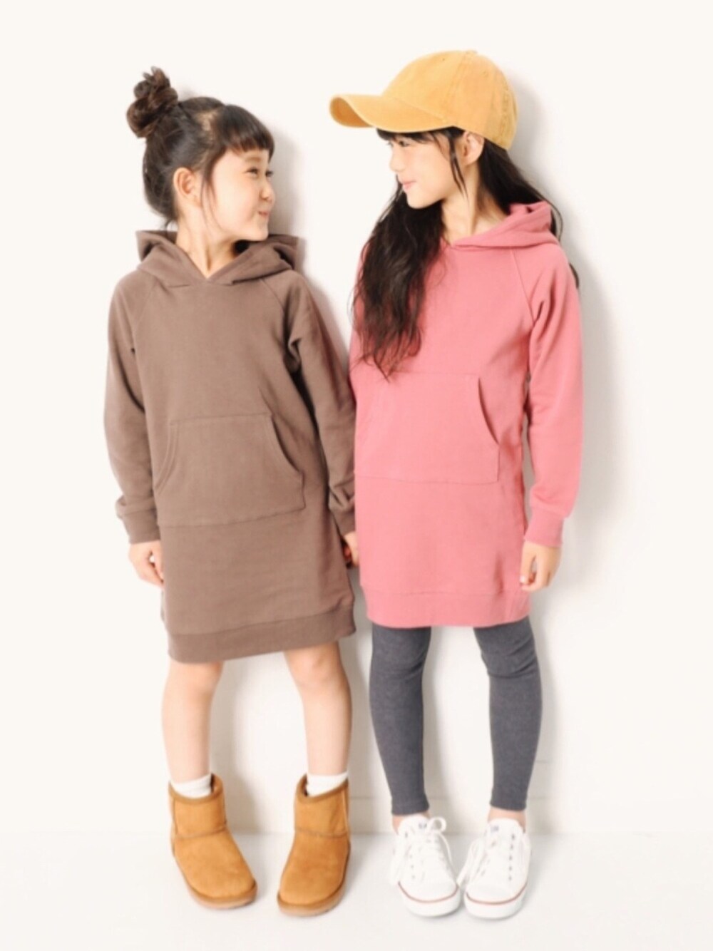 ブラウン系のワンピース、パープル系のワンピース、ホワイト系のスニーカーを着用したキッズの秋コーディネートの1枚目の写真