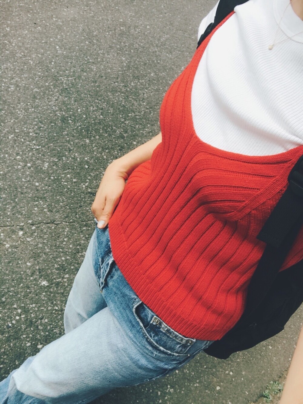 レッド系のキャミソール、ホワイト系のTシャツ/カットソー、ブルー系のデニムパンツを着用したレディースの春コーディネートの1枚目の写真