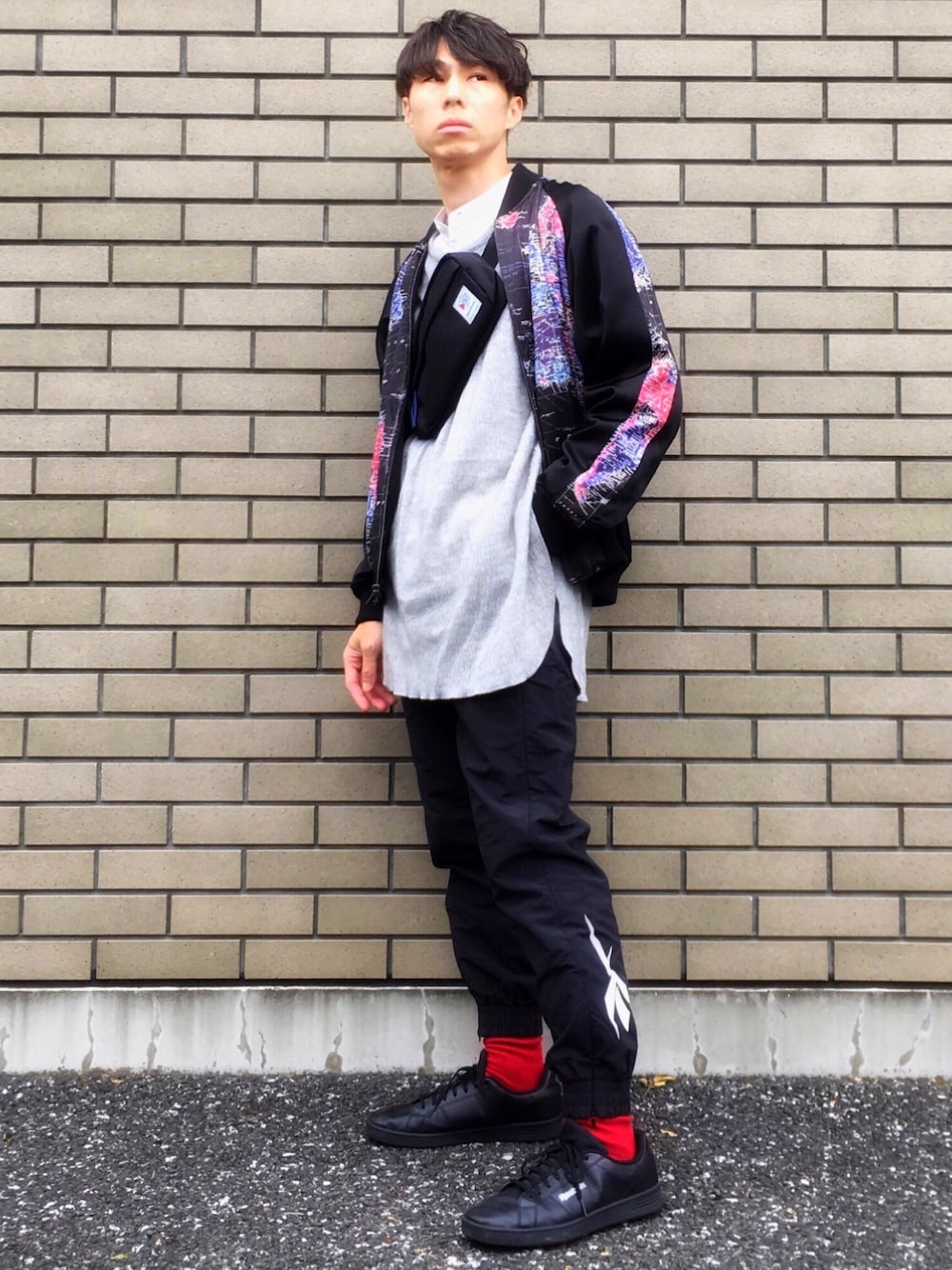 ブラック系のその他パンツ、ブラック系のスニーカー、グレー系のニット/セーターを着用したメンズの秋コーディネートの1枚目の写真