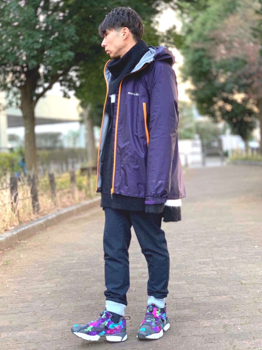 パープル系のマウンテンパーカー、ブラック系のニット/セーター、ホワイト系のTシャツ/カットソーを着用したメンズの冬コーディネートの1枚目の写真