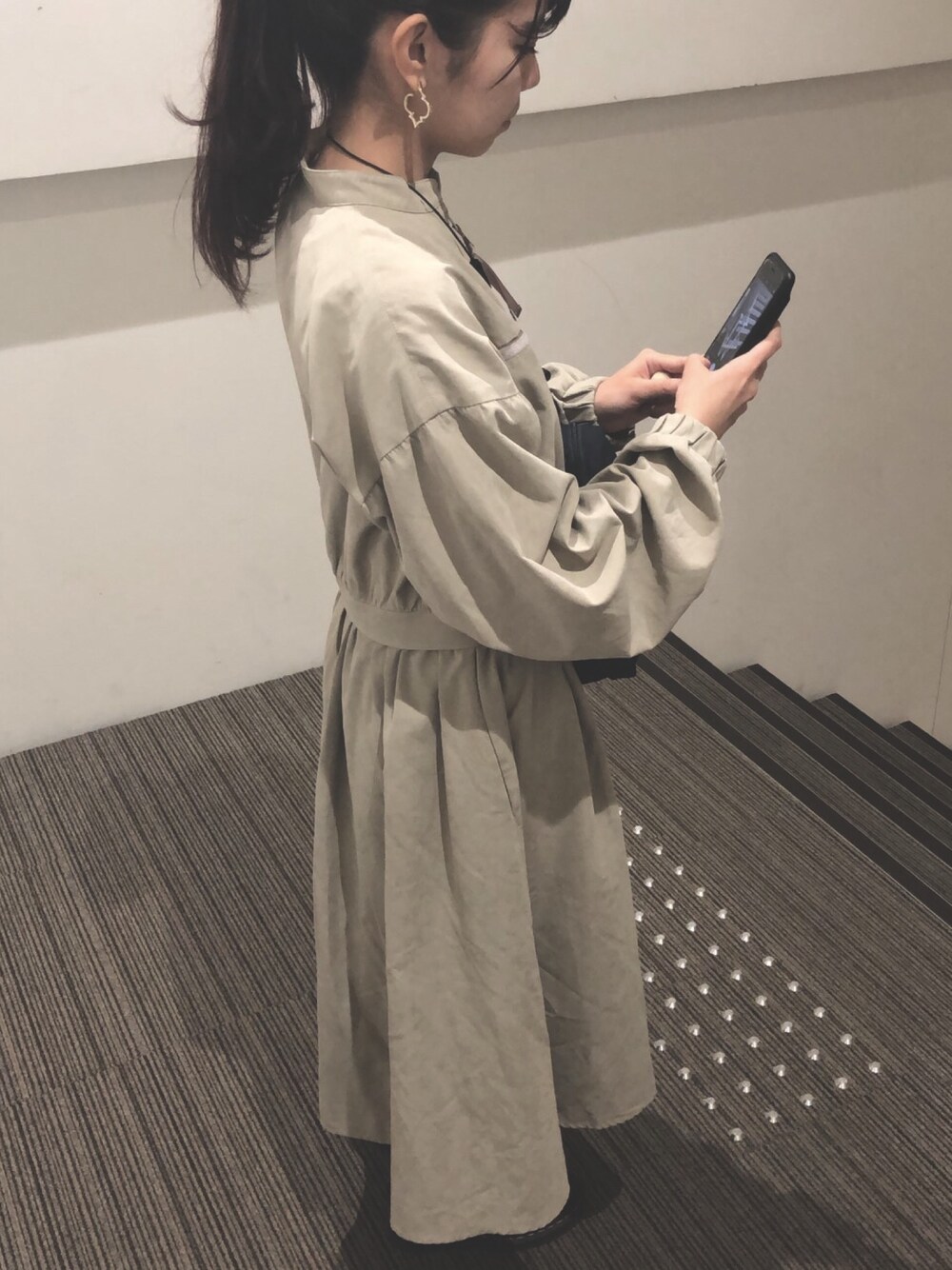 ベージュ系のブルゾン、ブラック系のブーツ、ブルー系のショルダーバッグを着用したレディースの秋コーディネートの1枚目の写真